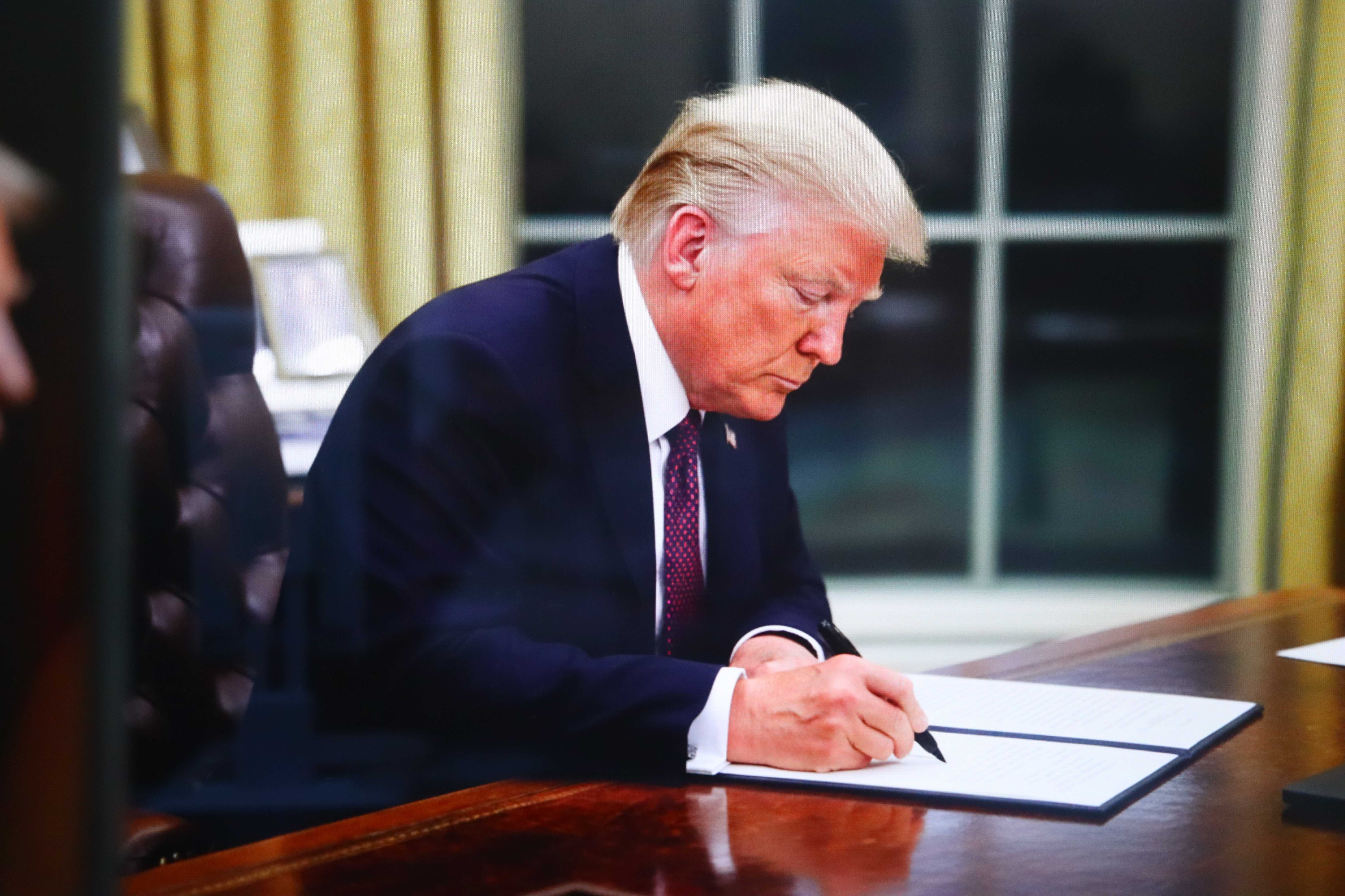 Donald Trump signe un document officiel à son bureau, New York, États-Unis - 27 novembre 2025.