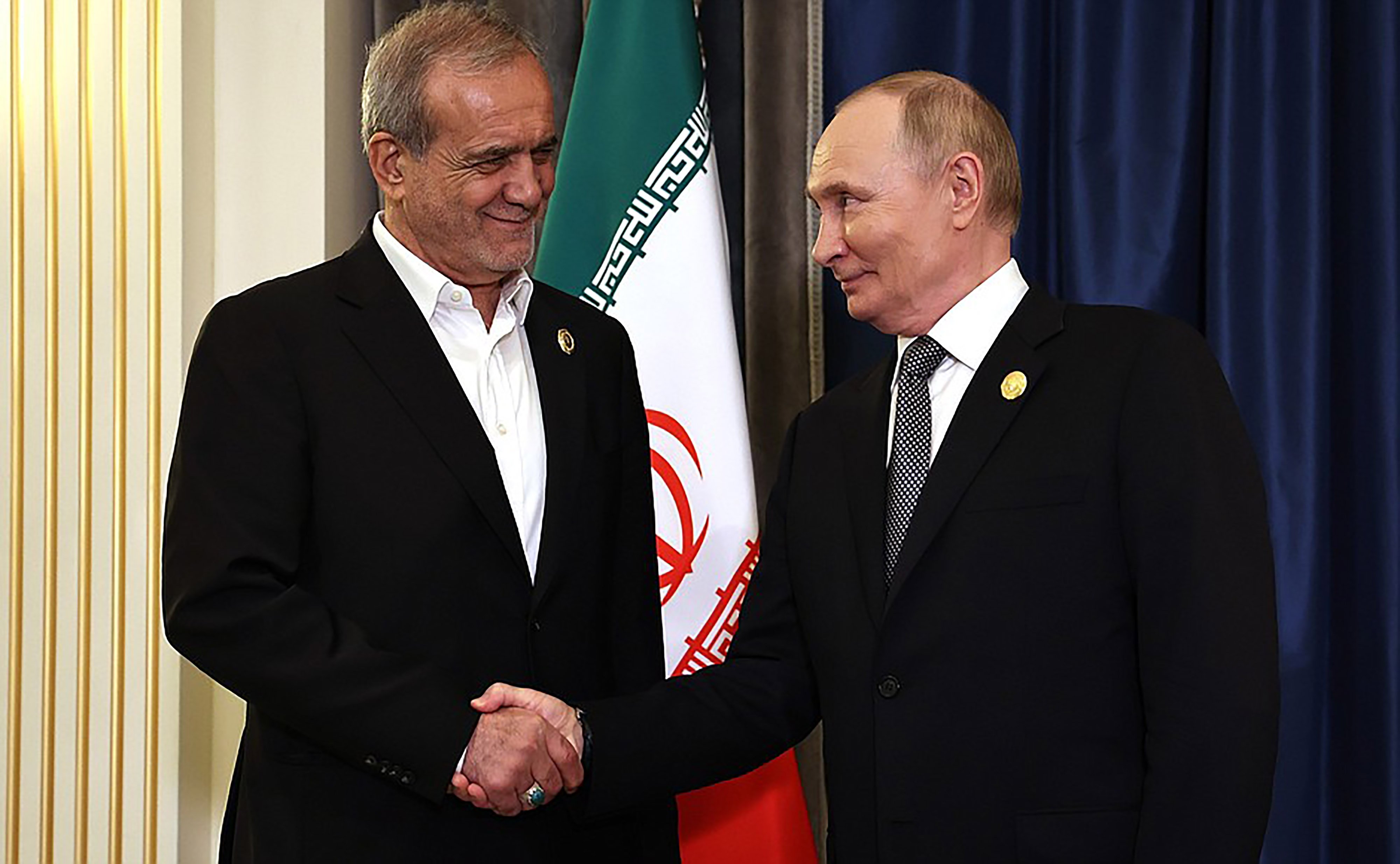 Le président russe Vladimir Poutine serre la main du président iranien Masoud Pezeshkian lors d'une réunion en marge du sommet de l'Organisation de coopération de Shanghai (OCS) à Tianjin, le 1er septembre 2025.