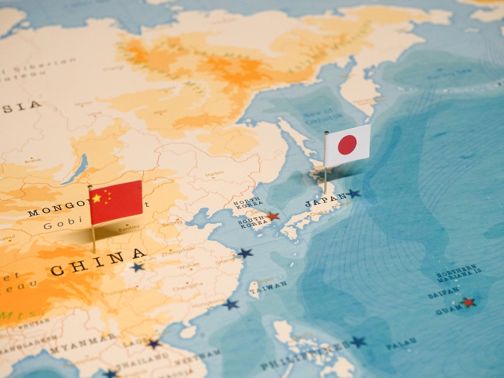 Les drapeaux de la Chine et du Japon sur une carte du monde.