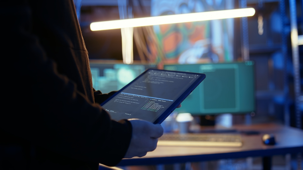 Individu codant sur une tablette numérique