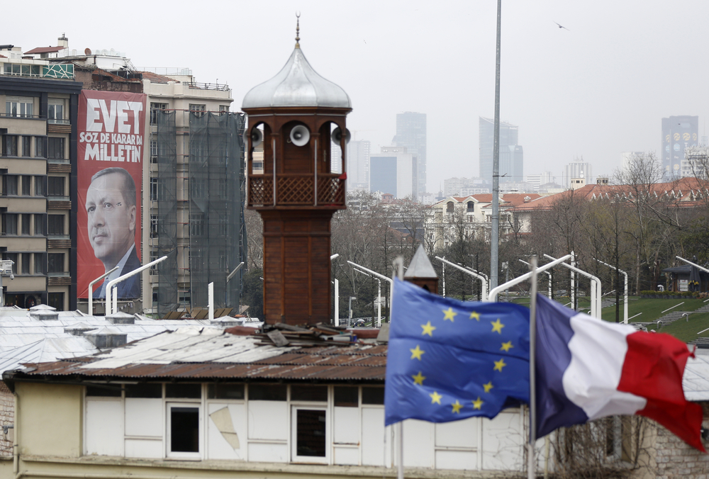 Une affiche d'Erdogan devant les drapeaux européen et français et le minaret de la mosquée de Taksim à Istanbul