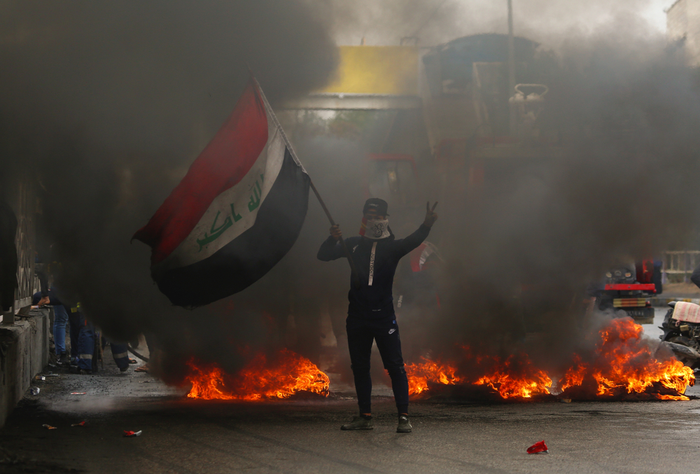 Un manifestant irakien bloque une rue pour protester contre le gouvernement irakien