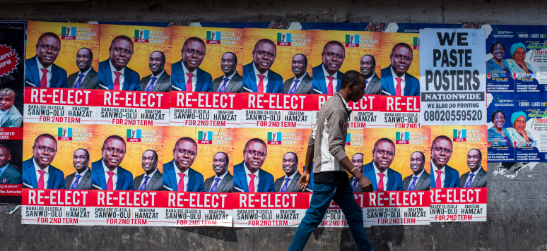 Un jeune homme passe devant les affiches de l'actuel gouverneur de l'État de Lagos, 15 octobre 2022