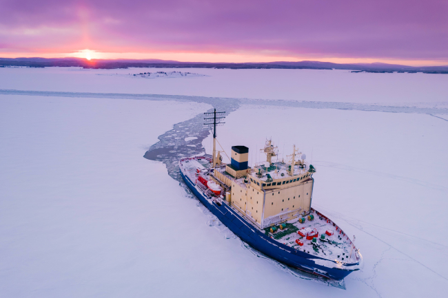 Bateau de déglaçage en Arctique sur fond de coucher de soleil