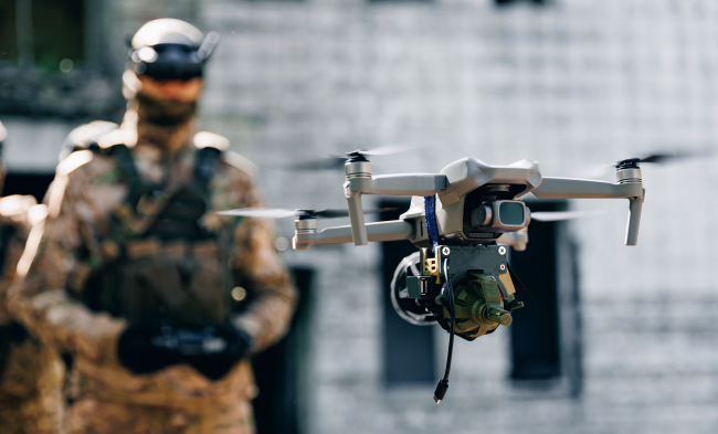 Drone en vol dirigé par un soldat