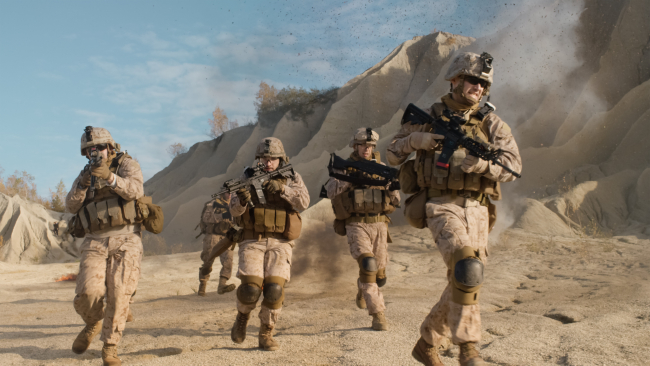 Escadron de soldats armés entièrement équipés qui courent et attaquent pendant les opérations militaires dans le désert.