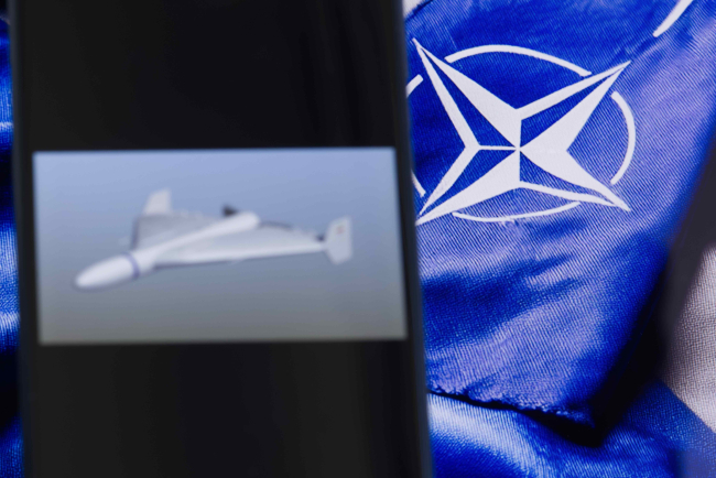 Symbole et drapeau de l'OTAN en arrière-plan, drone aérien au premier plan, Varsovie, Pologne, 10 septembre 2025.