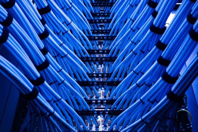 vue sur des câbles de données bleus disposés dans un rack de serveur