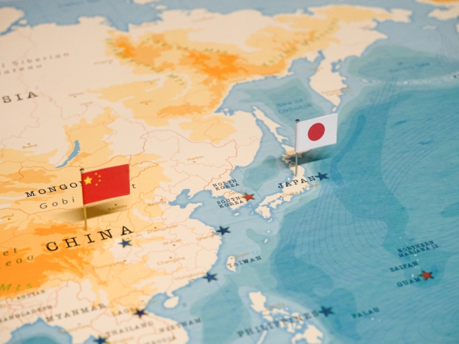 Les drapeaux de la Chine et du Japon sur une carte du monde.
