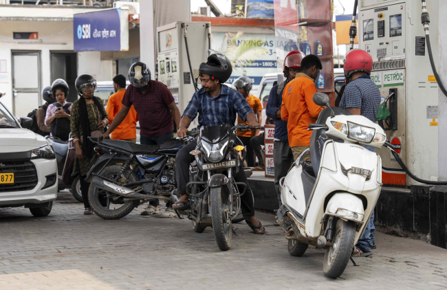 Un pompiste ravitaille des véhicules à une pompe à essence à Guwahati, en Inde, le 11 mars 2026.