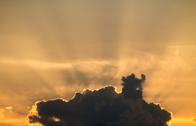 the glow of the sunset behind clouds