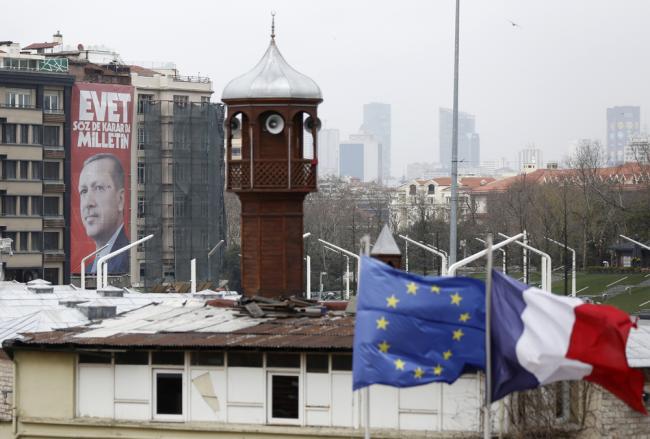 Une affiche d'Erdogan devant les drapeaux européen et français et le minaret de la mosquée de Taksim à Istanbul