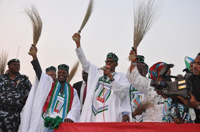 general_buhari_holding_a_broom_at_a_campign_rally.jpg