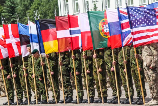 RUKLA, LITHUANIA - JUNE 8, 2015: NATO soldiers holding alliance flags