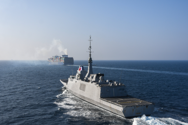 A French frigate escorts a cargo ship