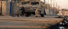 Des soldats de l'armée américaine du 3e régiment de cavalerie blindée se mettent à couvert derrière leur véhicule à Mossoul, en Irak, le 17 janvier 2008.