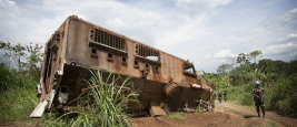 A MONUSCO Peacekeeper stands near the wreckage of a nepalese armored vehicle which was hit the previous year in an ambush from ADF militia in the Beni region, the 13th of March 2014.