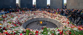 Yerevan, Armenia - April 24, 2018: Armenians laying flowers at the eternal flame in the center of the twelve slabs of Armenian Genocide memorial 