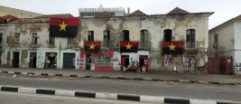 Residents sit outside on election day in Angola underneath the flags of the ruling People's Movement for the Liberation of Angola (MPLA) party, on 23 August 2017