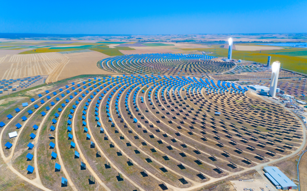 Seville, Spain - June 10, 2018: Solar tower surrounded by mirror panels harnessing the sun's rays to provide alternative renewable green energy. Situated in Andalucia, Spain.